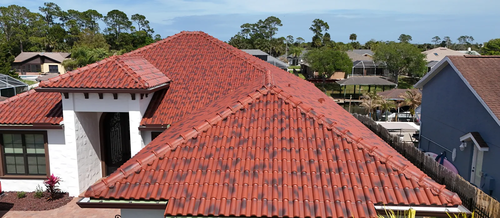 A finished CS clay tile roof in rustic red, laid over hips and valleys on a single-storey home