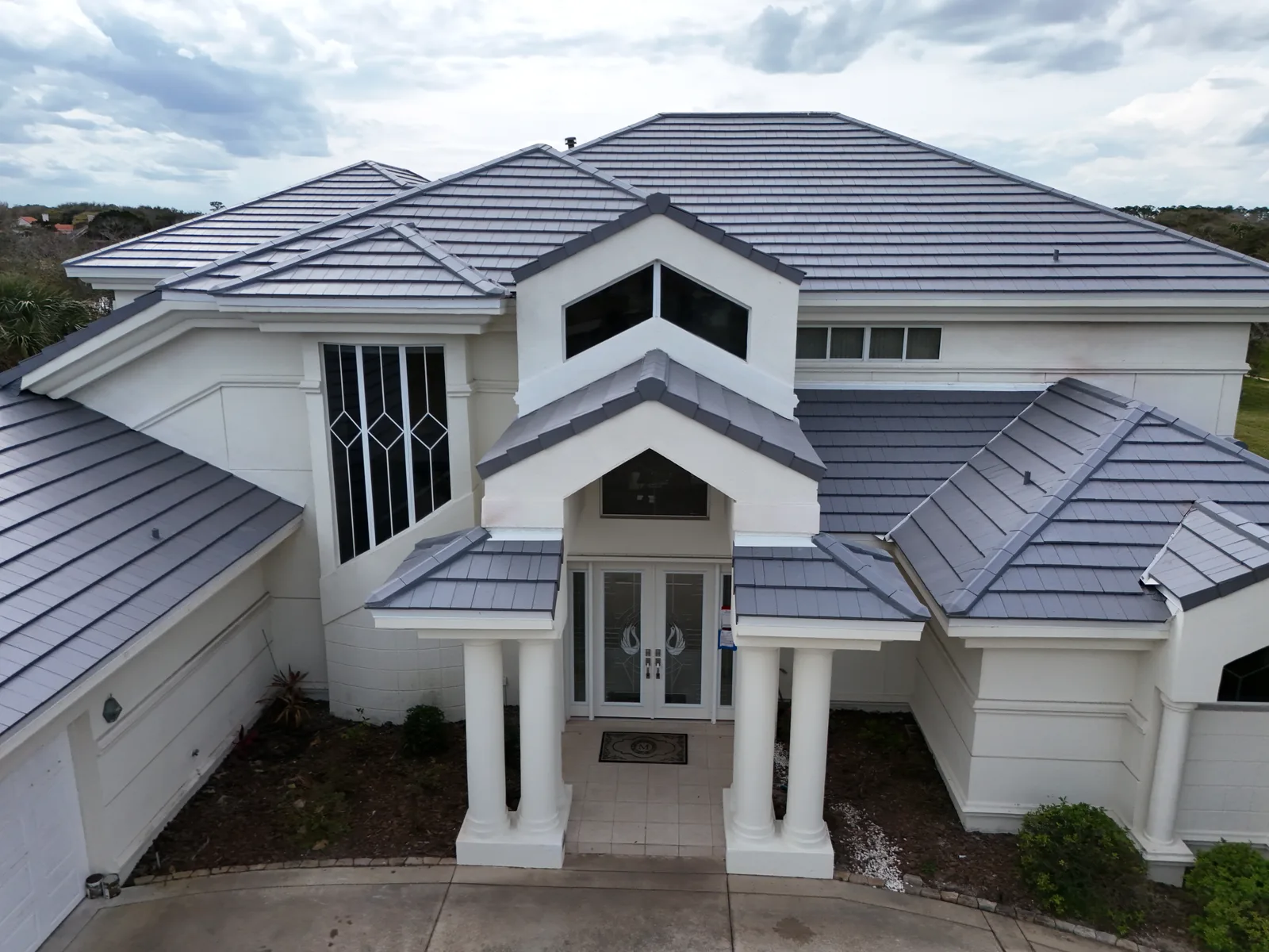 Grey CS clay tile roof over a columned home entrance