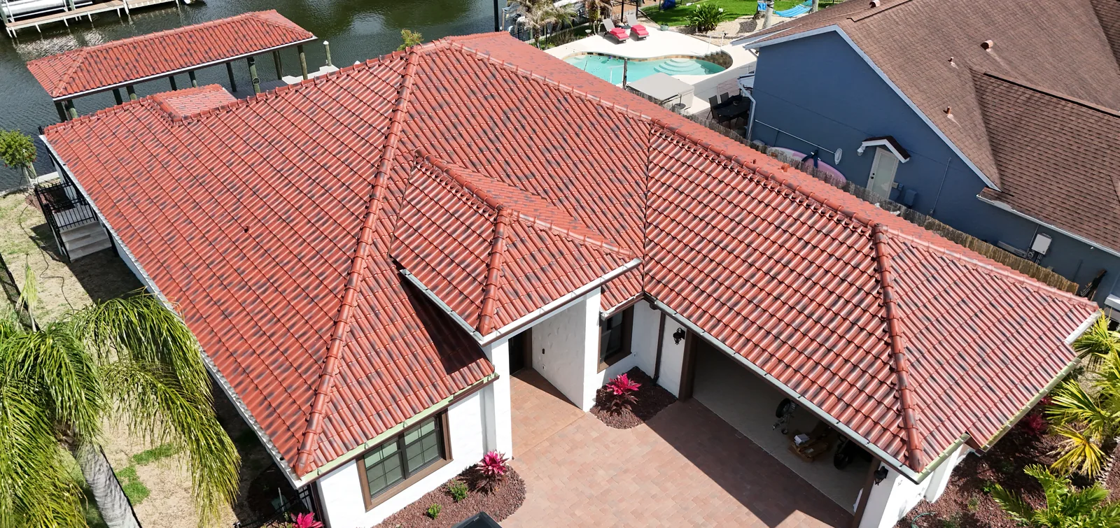 Aerial view of a waterfront home roofed in red barrel clay tile