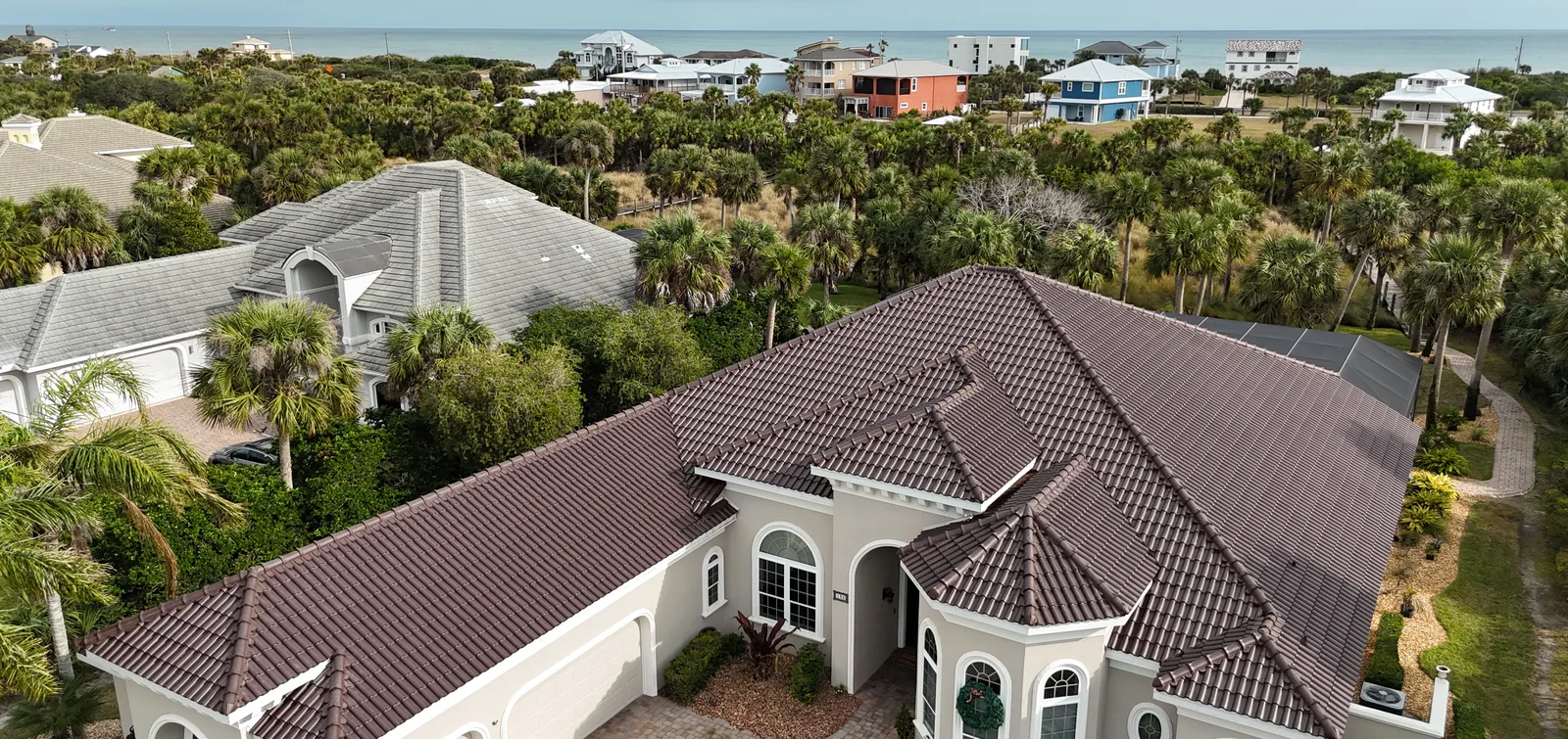 Aerial view of a brown barrel clay tile roof on a large waterfront home
