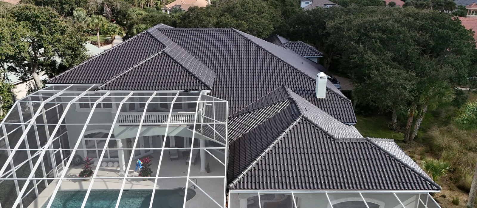 A titanium-colored CS clay tile roof seen from above, with the coastline behind it